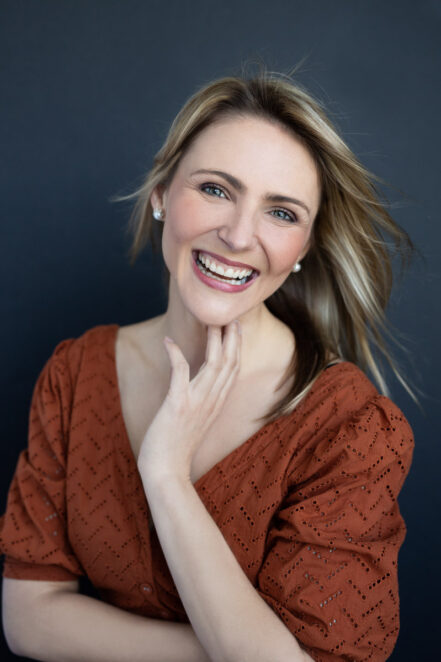 Portrait of a smiling woman touching her chin by Joanna Zydel Bunbury Portrait Photographer